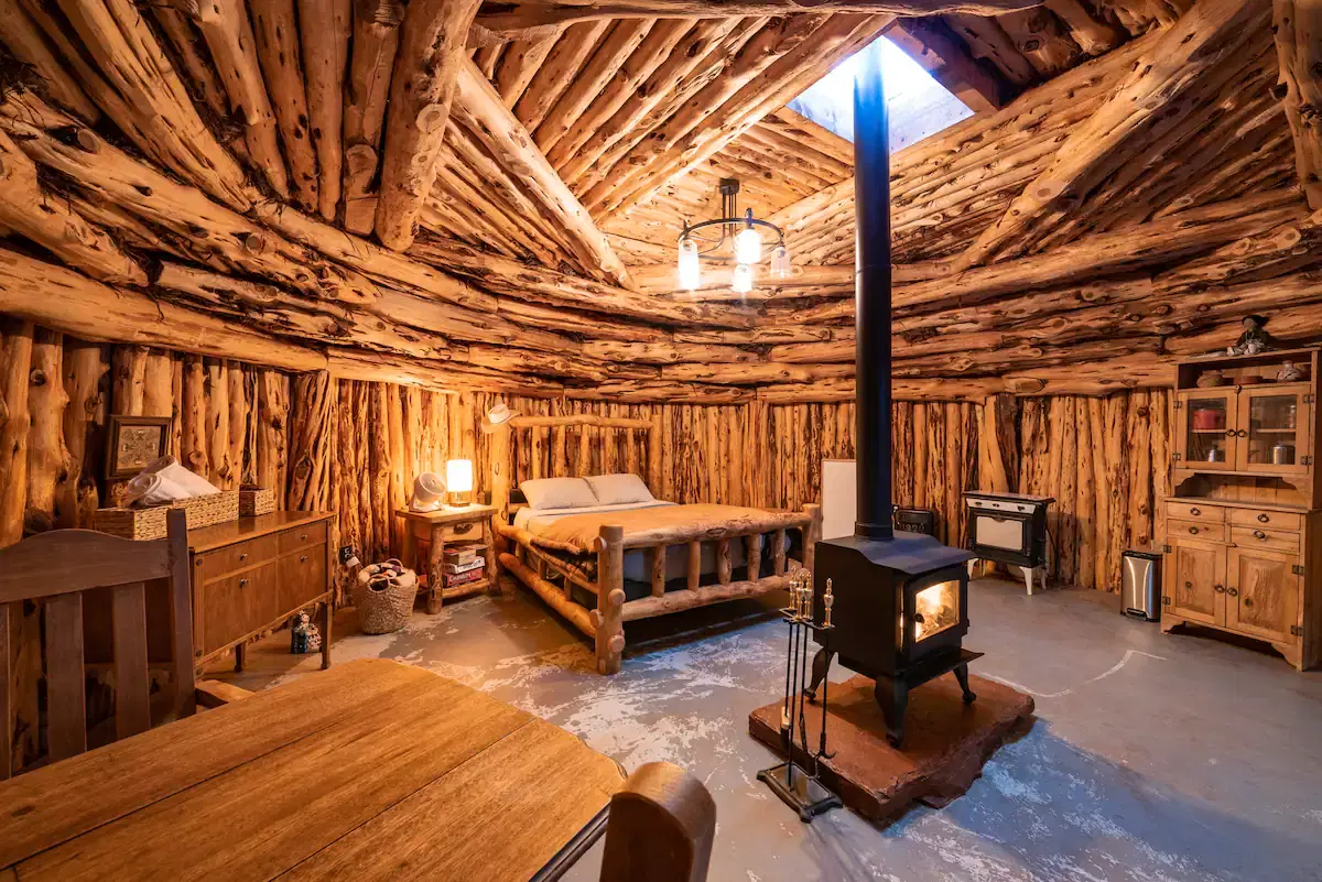 A rustic cabin interior with wooden walls and ceiling features a skylight.